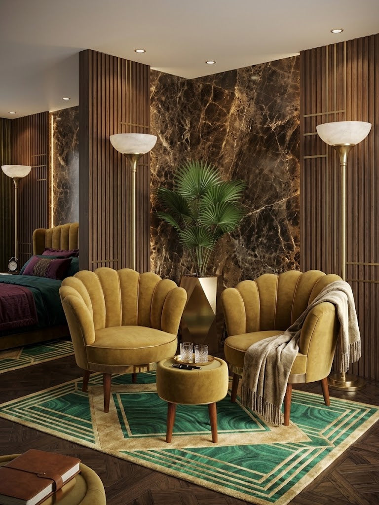 A luxury modern living room featuring two scalloped mustard yellow velvet armchairs and a matching round ottoman on a green geometric patterned rug. The room has dark wood slatted walls, a dark brown marble accent wall, and a bed in the background.