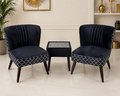 A pair of dark navy velvet club chairs with white geometric trellis-patterned fabric on the seat and back, paired with a matching dark navy side table featuring a white geometric inlay, set against a neutral beige wall with home decor.