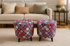 Two round upholstered ottomans with colorful patchwork diamond patterns and dark tapered legs, placed in front of a beige sofa in a living room setting.
