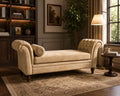 A classic tufted chaise lounge chaise lounge chaise lounge chaise lounge in a warm beige velvet fabric, styled in a cozy, traditional living room setting with a patterned rug, bookshelves, and a floor lamp.