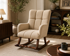 A beige upholstered rocking chair with a high back and tufted cushioning, set in a warm, modern living room with wooden furniture and plants.